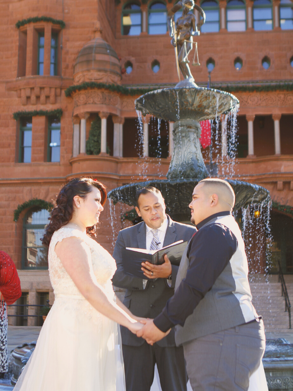 Everlasting Elopements couple holding hands staring into each others eyes during ceremony in front of a fountain at San Antonio Courthouse