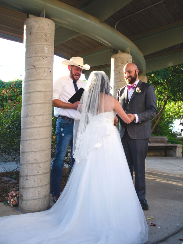 Everlasting Elopements couple holding hands looking at each other during ceremony at Riverwalk Overlook Pavillion