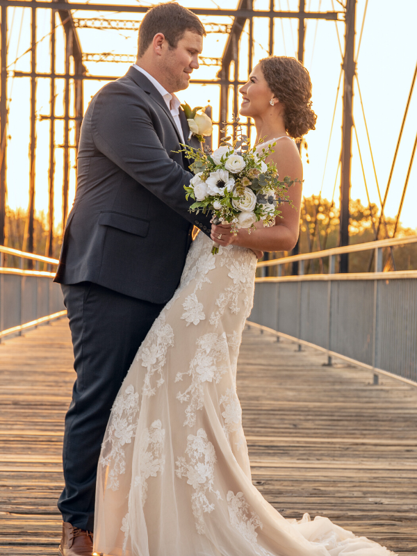 Everlasting Elopements couple smiling at each other on a bridge during sunset at Milltown Historic District 