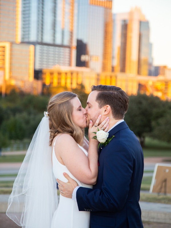 Everlasting Elopements couple kissing in front of city skyline at Butler Park