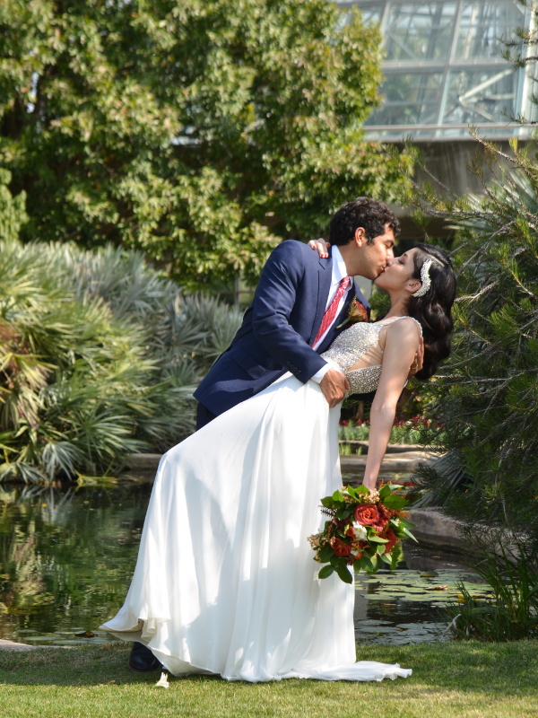 Everlasting Elopements couple kissing in front of beautiful pond surrounded by greenery at San Antonio Botanical Gardens