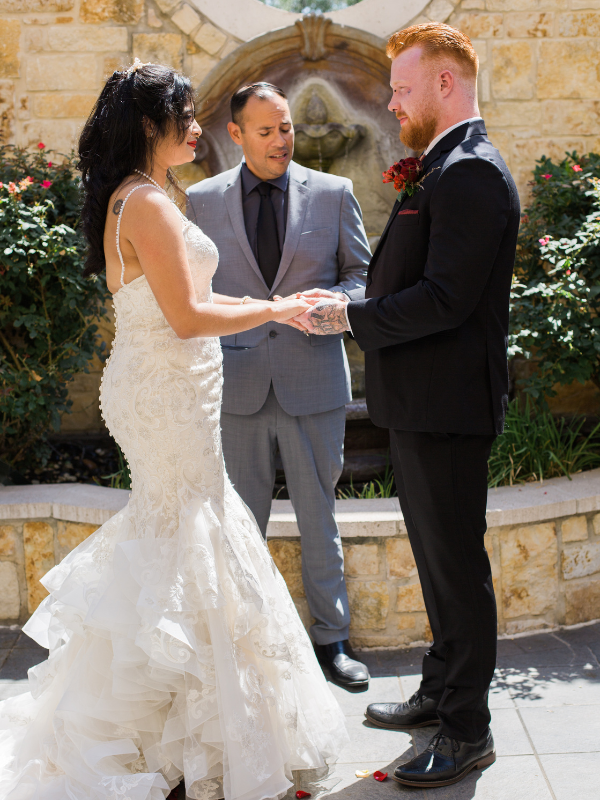 Everlasting Elopements couple holding hands during ceremony standing in front of stone wall at Maggiano's Austin