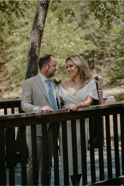 Everlasting Elopements couple looking and smiling each other standing on a bridge.