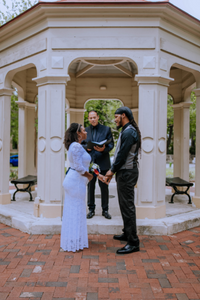 Reverend Rene Esparza, with Everlasting Elopements, standing in front of a gazebo with a couple during their ceremony at King William Park in San Antonio, Texas. 