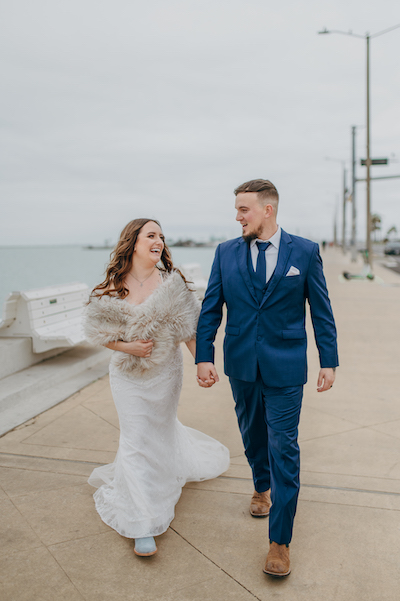 Everlasting Elopements  couple walking on pier laughing 