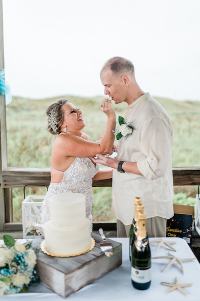 Everlasting Elopements eating cake after small wedding on beach pier